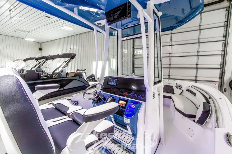 Slide: The Image of 2026 Tidewater 220 LXF boat interior with modern dashboard and seating in a showroom. - 26
