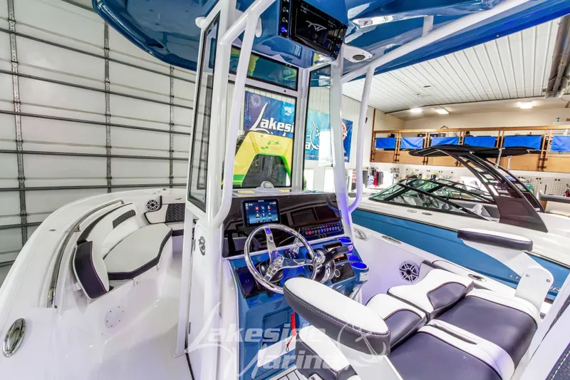 Slide: The Image of 2026 Tidewater 220 LXF boat interior with modern dashboard and seating in showroom. - 28