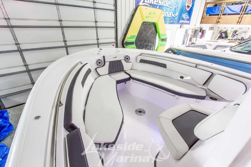 Slide: The Image of 2026 Tidewater 220 LXF boat interior with white seating in a marina showroom. - 39