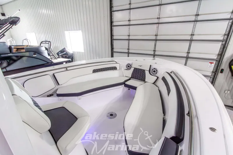 Slide: The Image of 2026 Tidewater 220 LXF boat interior with cushioned seating in a marina setting. - 40