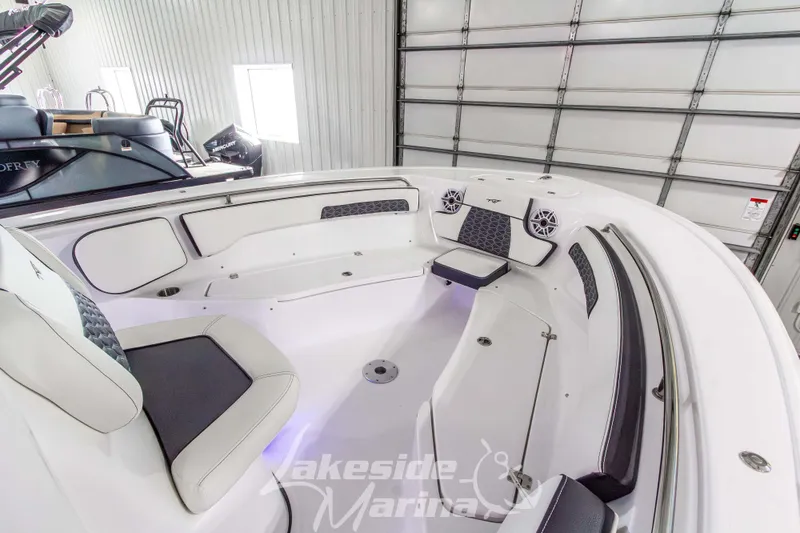 Slide: The Image of 2026 Tidewater 220 LXF boat interior with cushioned seating and modern design in a marina setting. - 48