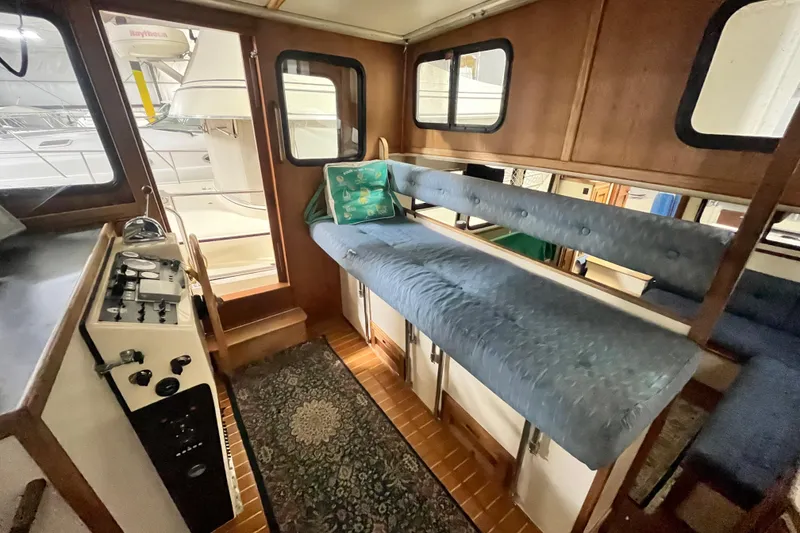 Slide: The Image of 1999 Nordic Tug 32 interior with blue seating and control panel. - 16