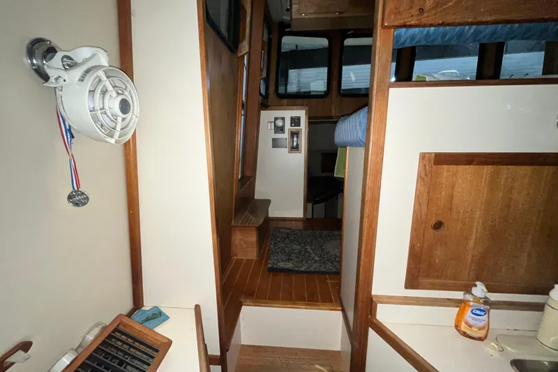 Slide: The Image of Interior of 1999 Nordic Tug 32, featuring wood paneling and compact design. - 21