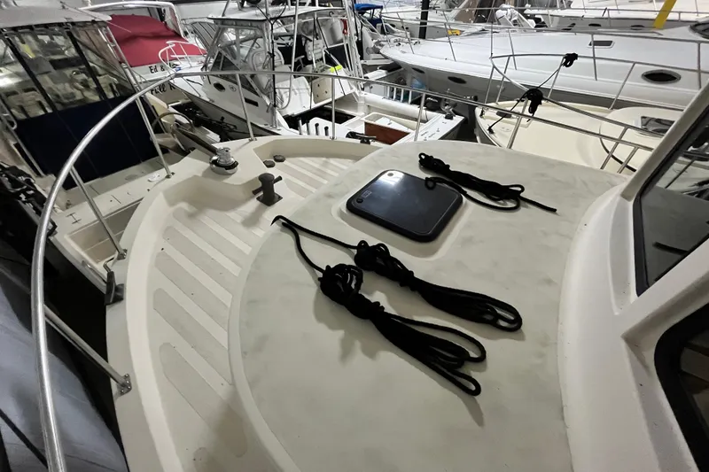 Slide: The Image of 1999 Nordic Tug 32 boat deck with ropes, docked among other vessels. - 22