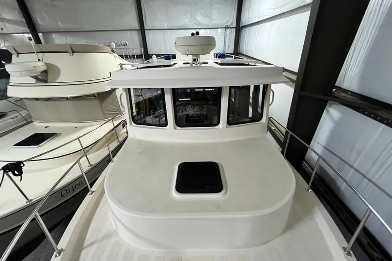 Slide: The Image of 1999 Nordic Tug 32 in storage, showcasing deck and cabin details. - 23