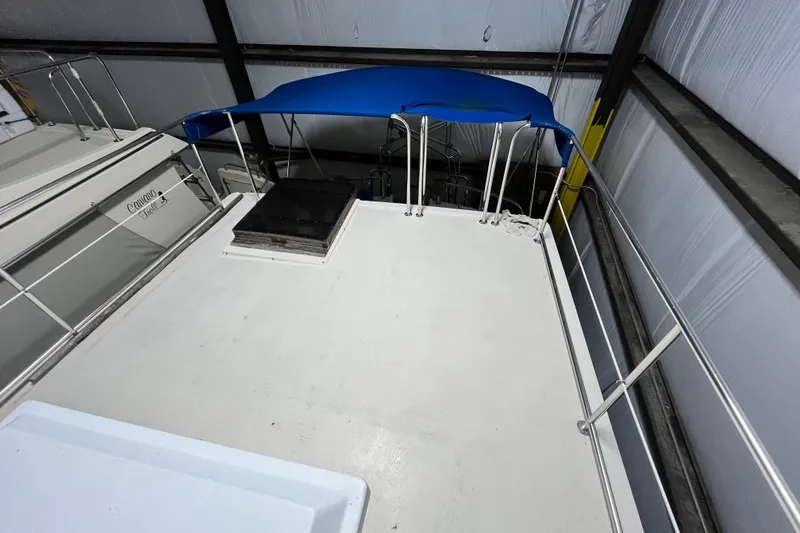 Slide: The Image of 1999 Nordic Tug 32 boat deck with blue canopy in storage facility. - 4