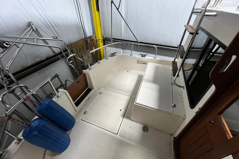 Slide: The Image of 1999 Nordic Tug 32 boat interior with seating and storage in a covered area. - 6