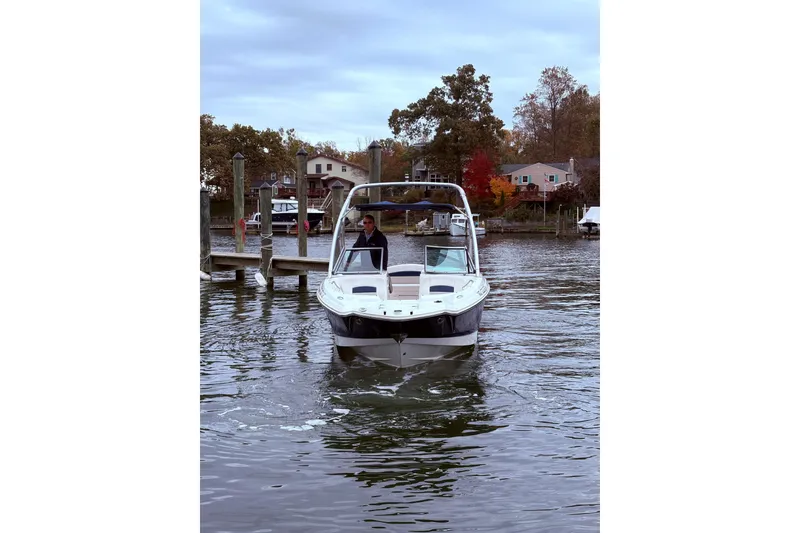 Slide: The Image of 2009 Chaparral Sunesta 244 boat on water near dock, surrounded by autumn trees. - 2