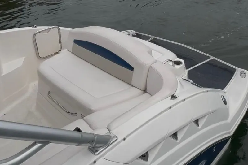 Slide: The Image of 2009 Chaparral Sunesta 244 boat interior with white seating and blue accents on water. - 9