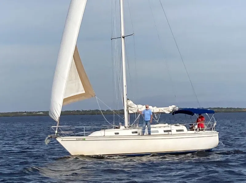 The Image of 1987 Pearson 36-2 sailboat on open water with two people onboard. - 0