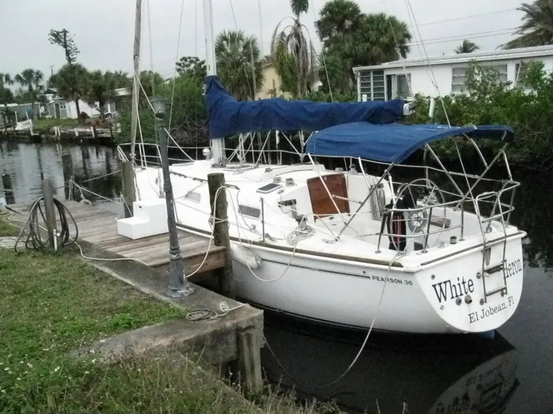 Slide: The Image of 1987 Pearson 36-2 sailboat docked by a canal with blue canopy. - 1