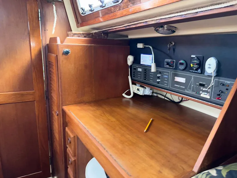 Slide: The Image of Navigation station on a 1987 Pearson 36-2 sailboat with wooden desk and control panel. - 13
