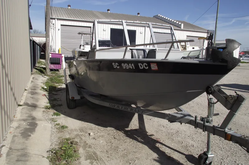 Slide: The Image of 2012 Smoker Craft Pro Angler XL 162 boat on trailer, parked outdoors. - 2