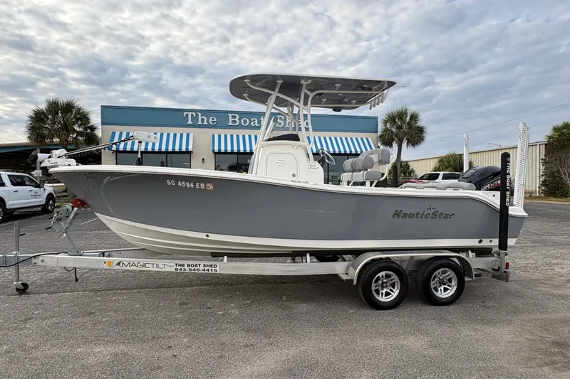 The Image of 2022 NauticStar 2302 Legacy boat on trailer outside dealership. - 1