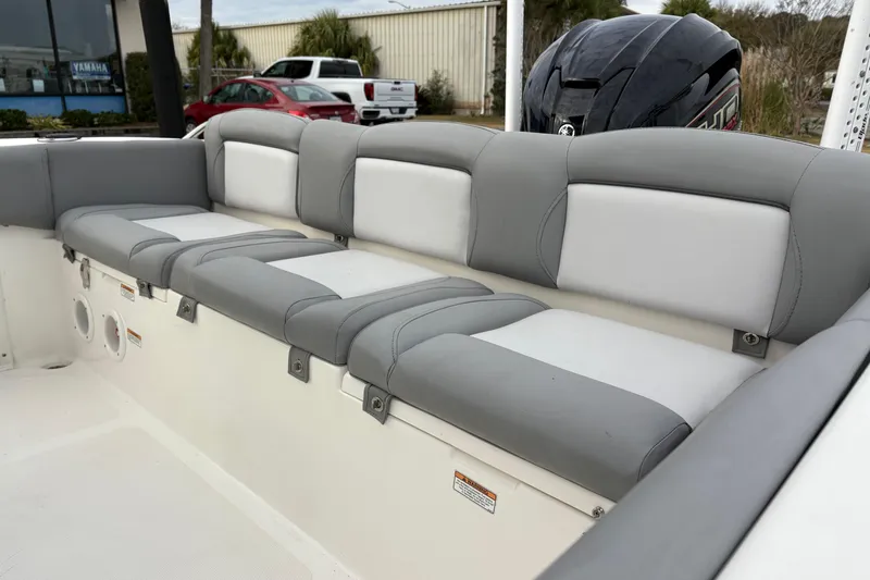 Slide: The Image of 2022 NauticStar 2302 Legacy boat interior with gray and white cushioned seating. - 11