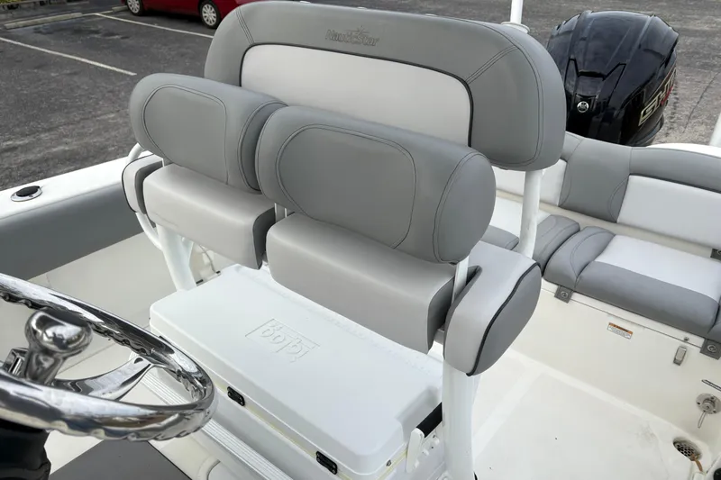 Slide: The Image of 2022 NauticStar 2302 Legacy boat interior with gray seating and steering wheel. - 13