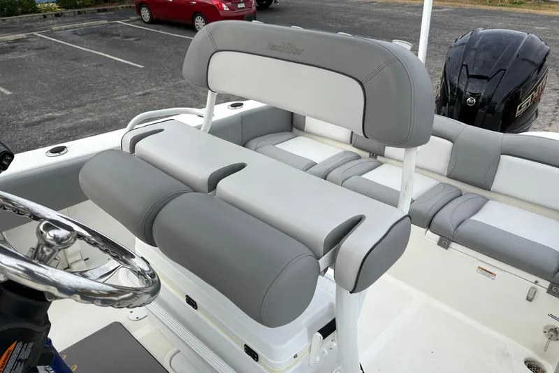 Slide: The Image of 2022 NauticStar 2302 Legacy boat interior with gray seating and steering wheel. - 14