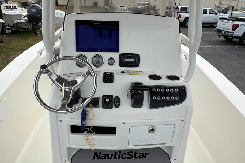 Slide: The Image of 2022 NauticStar 2302 Legacy boat console with steering wheel and navigation controls. - 18