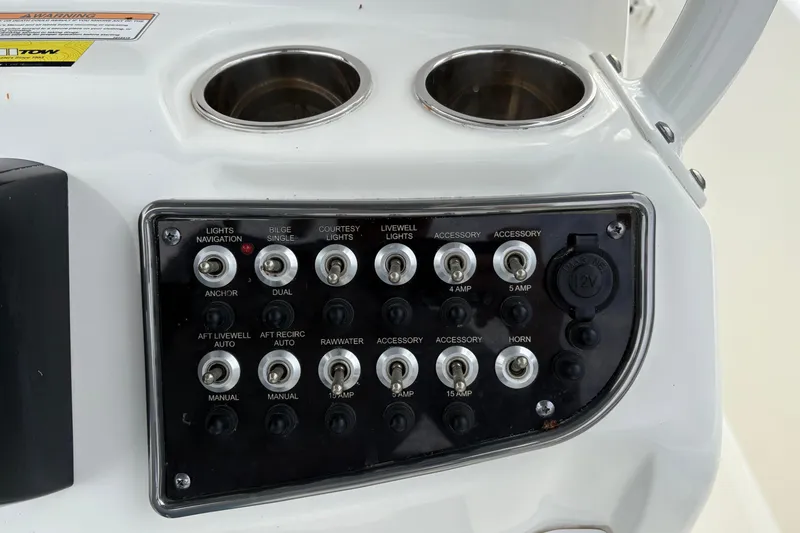 Slide: The Image of Control panel of 2022 NauticStar 2302 Legacy boat with switches and cup holders. - 19