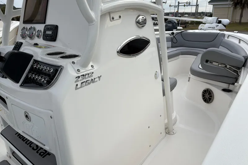 Slide: The Image of 2022 NauticStar 2302 Legacy boat interior with control panel and seating area. - 24