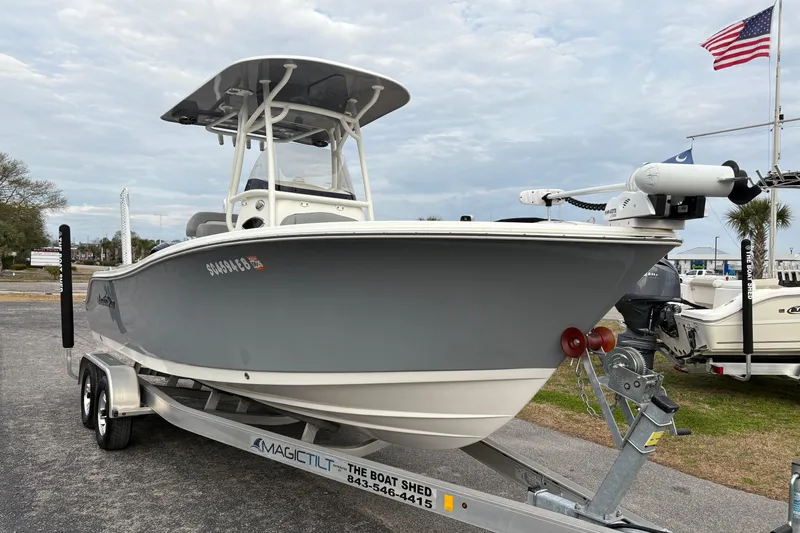 Slide: The Image of 2022 NauticStar 2302 Legacy boat on trailer, displayed outdoors with American flag. - 6