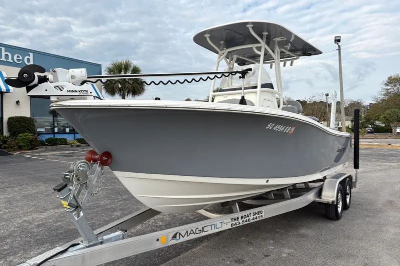 Slide: The Image of 2022 NauticStar 2302 Legacy boat on trailer, featuring Minn Kota trolling motor. - 8