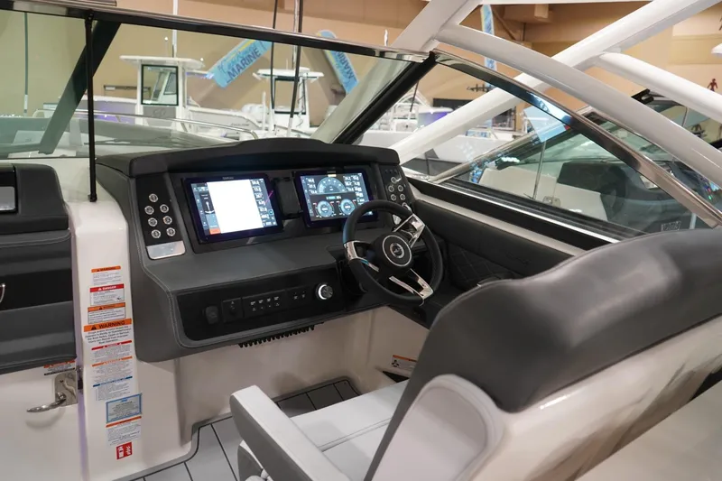 The Image of 2026 Chaparral 310 OSX boat displayed indoors on a blue floor. - 0