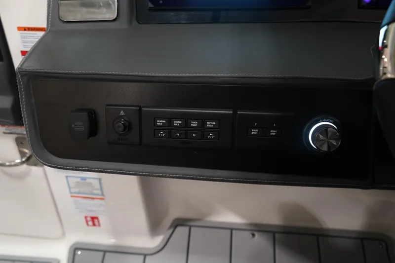 Slide: The Image of 2026 Chaparral 310 OSX boat interior at a boat show, showcasing seating and helm area. - 13