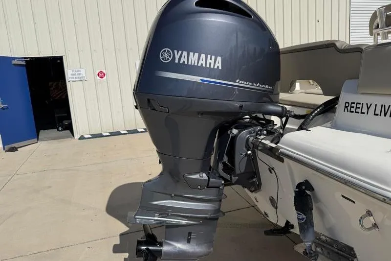 Slide: The Image of 2023 Key West 203 FS boat with Yamaha outboard motor in a marina setting. - 13