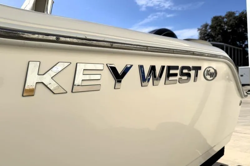Slide: The Image of 2023 Key West 203 FS boat logo on side under clear blue sky. - 44