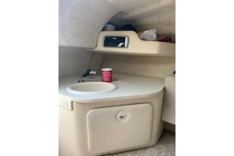 Slide: The Image of 2003 Sea Ray 225 Weekender cabin interior with sink and storage. - 16
