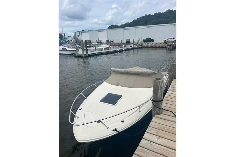 Slide: The Image of 2003 Sea Ray 225 Weekender boat docked at marina, overcast sky. - 2
