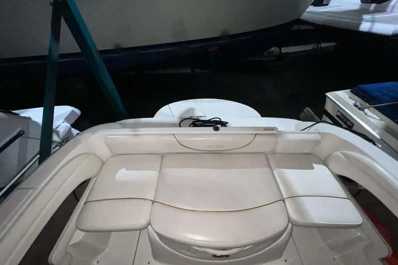 Slide: The Image of 2003 Sea Ray 225 Weekender boat interior with white cushioned seating. - 4