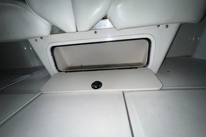 Slide: The Image of 2003 Sea Ray 225 Weekender storage compartment with open hatch, white interior. - 7