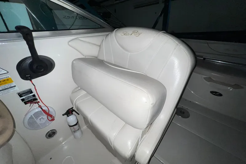 Slide: The Image of 2003 Sea Ray 225 Weekender boat interior with white seating and control panel. - 8