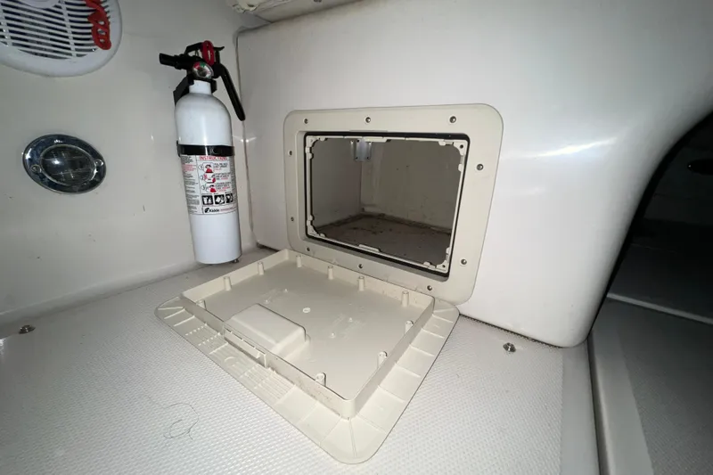 Slide: The Image of 2003 Sea Ray 225 Weekender interior with fire extinguisher and open storage compartment. - 9