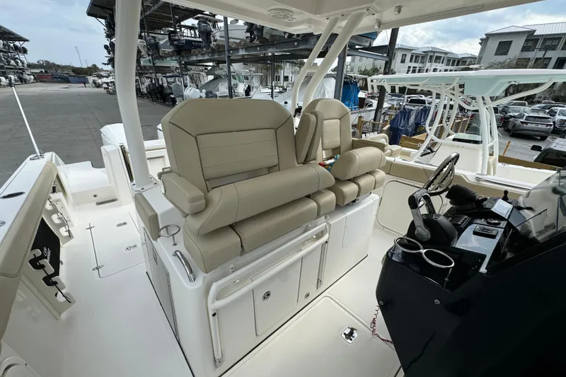 Slide: The Image of 2018 Pursuit S 328 Sport boat interior with beige seating and helm station. - 10