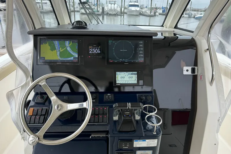 Slide: The Image of 2018 Pursuit S 328 Sport boat cockpit with navigation screens and steering wheel. - 12