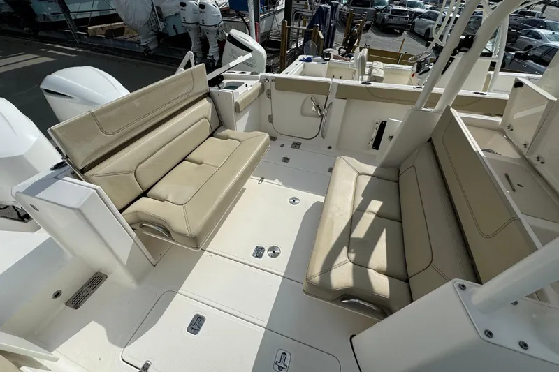 Slide: The Image of 2018 Pursuit S 328 Sport boat interior with beige seating and spacious layout. - 19