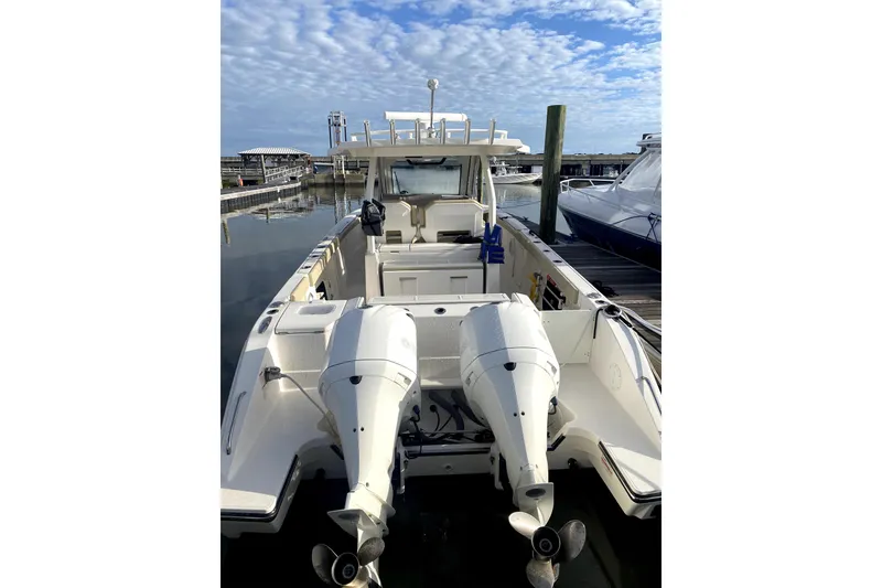 Slide: The Image of 2018 Pursuit S 328 Sport boat with dual outboard engines docked at marina. - 4