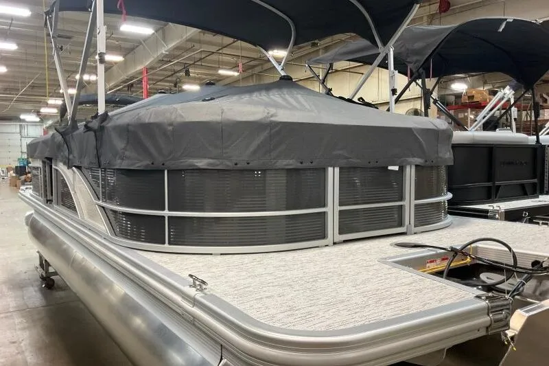 Slide: The Image of 2026 Bennington 22SXSR pontoon boat with cover in a showroom setting. - 3