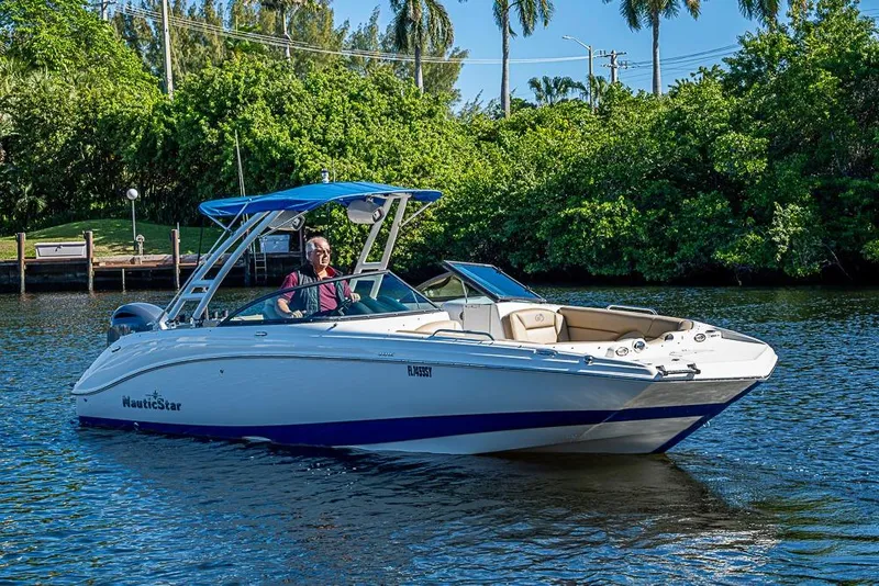 The Image of 2019 NauticStar 243DC Sport Deck boat cruising on a sunny day. - 0