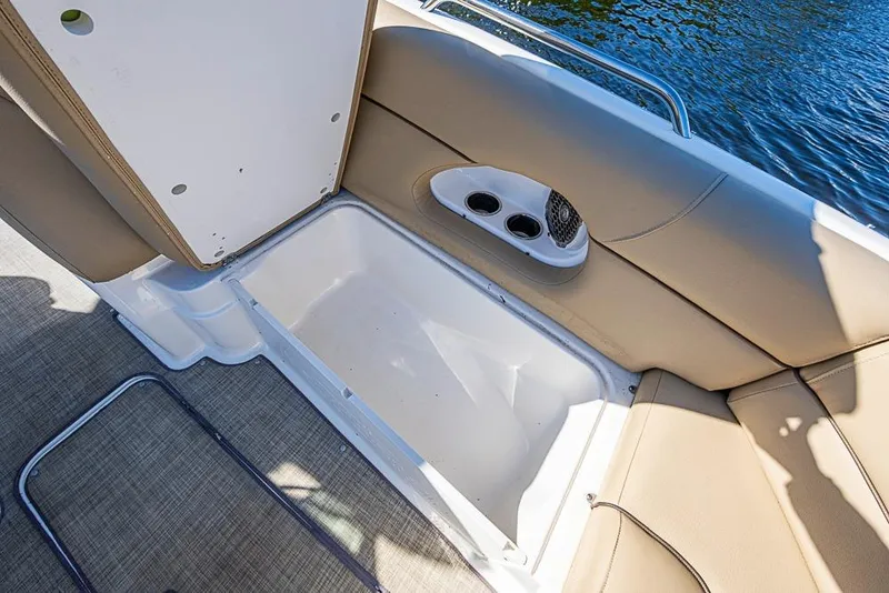 Slide: The Image of 2019 NauticStar 243DC Sport Deck boat interior with storage compartment and cup holders. - 12
