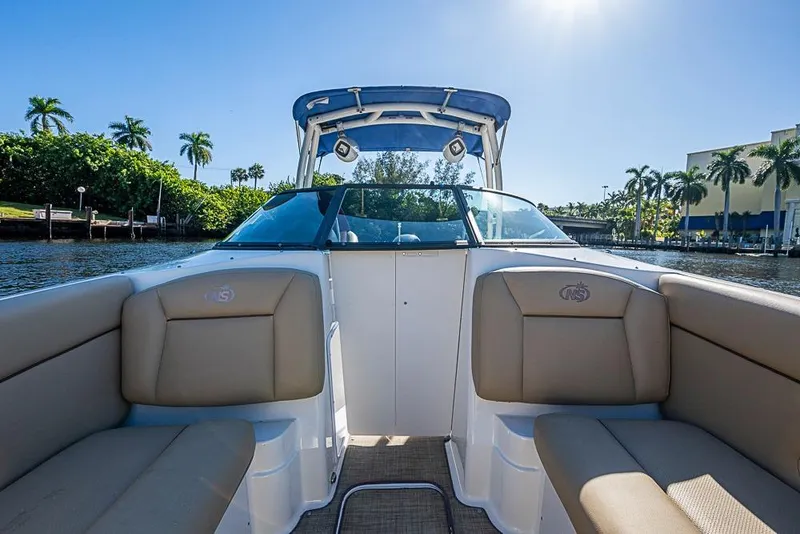Slide: The Image of 2019 NauticStar 243DC Sport Deck boat interior with tan seating, on a sunny day. - 15