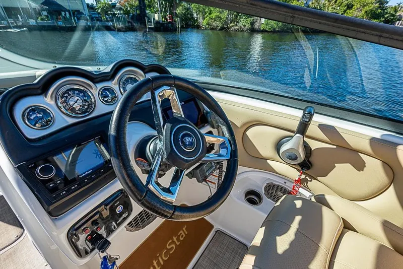 Slide: The Image of 2019 NauticStar 243DC Sport Deck boat interior with steering wheel and control panel. - 19