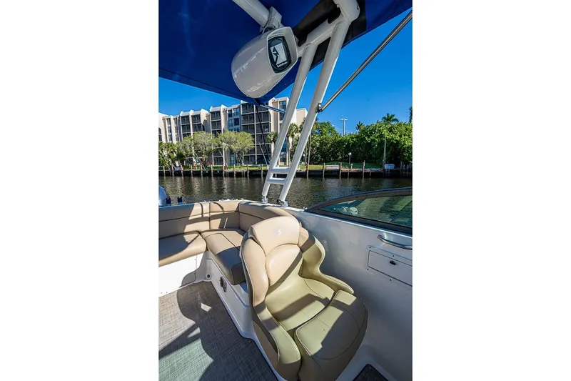 Slide: The Image of 2019 NauticStar 243DC Sport Deck boat interior with seating and blue canopy. - 21