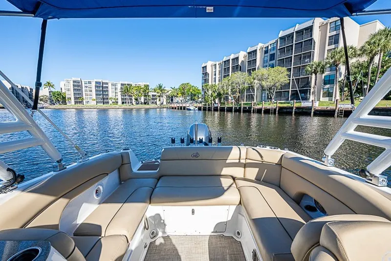 Slide: The Image of 2019 NauticStar 243DC Sport Deck boat with waterfront view and modern buildings. - 22