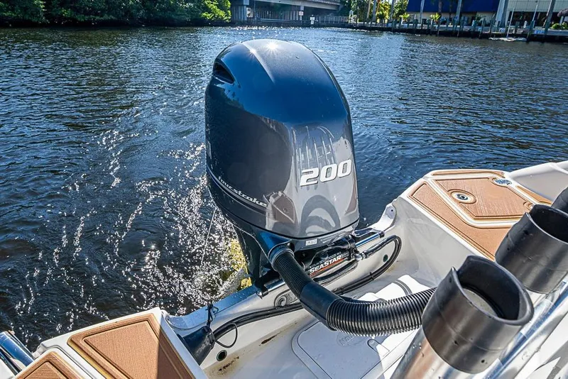Slide: The Image of 2019 NauticStar 243DC Sport Deck boat with powerful 200 horsepower engine on water. - 3