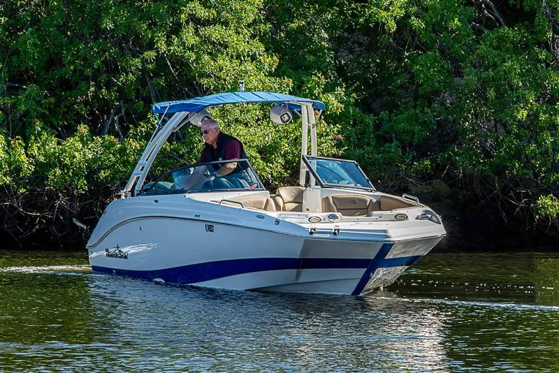 Slide: The Image of 2019 NauticStar 243DC Sport Deck boat cruising on a calm river. - 30
