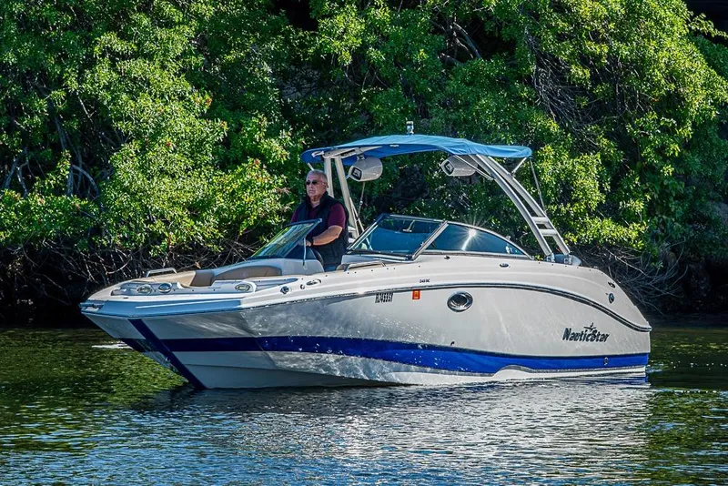 Slide: The Image of 2019 NauticStar 243DC Sport Deck boat cruising on a calm waterway. - 31